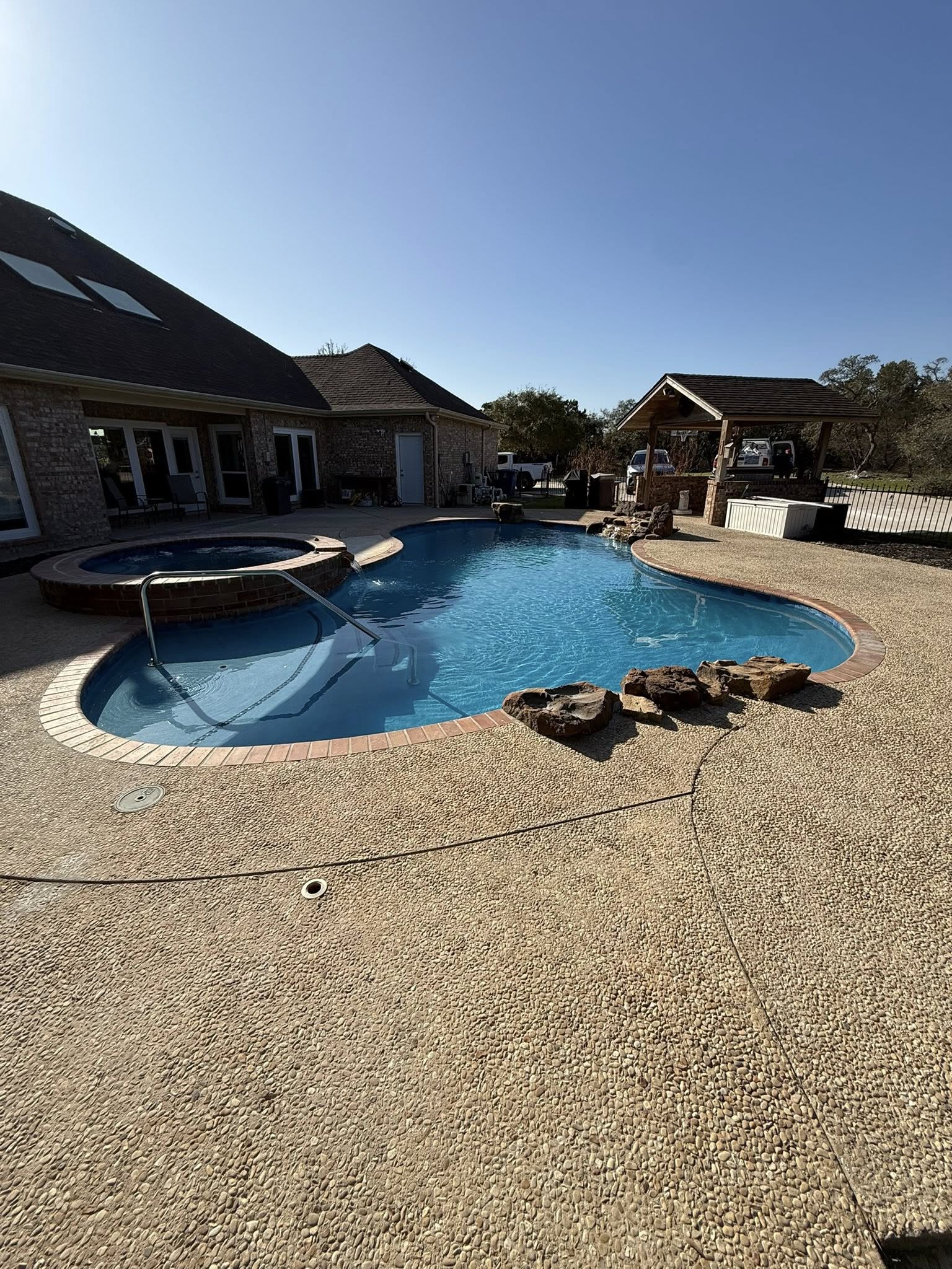 Pool with spa, brick coping, and covered patio