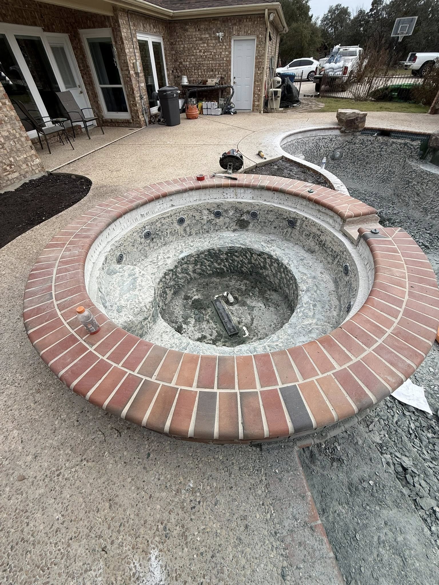 Spa with pebble and brick coping before